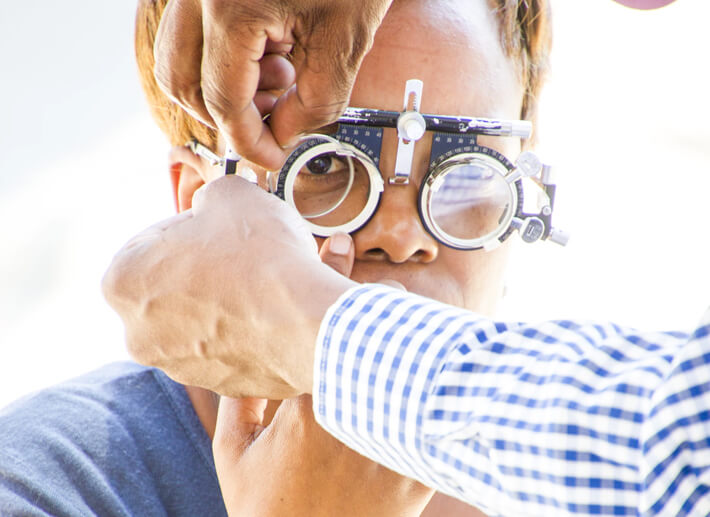 Eye care professional conducting a detailed vision measurement and prescription fitting.